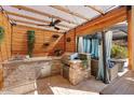 Well-equipped outdoor kitchen with stone countertops and a pergola at 13007 W Lowden Rd, Peoria, AZ 85383