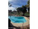 Inviting kidney-shaped pool with a brick patio and lush greenery at 13248 N 12Th Pl, Phoenix, AZ 85022