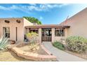 Inviting front entrance with a tiled porch and desert landscaping creating a warm and welcoming curb appeal at 14615 N 28Th St, Phoenix, AZ 85032