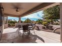 Covered patio with stamped concrete flooring, ceiling fan, and outdoor dining set, perfect for entertaining at 17061 W Peregrine Ln, Surprise, AZ 85387