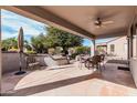 Cozy covered patio with a dining table, chairs, and outdoor seating area surrounded by desert landscaping at 17061 W Peregrine Ln, Surprise, AZ 85387