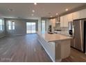 Spacious kitchen with island, stainless steel appliances, and light wood floors at 17299 W Desert Sage Dr, Goodyear, AZ 85338