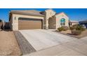 A home's concrete driveway leads to an attached garage, enhanced by an elegant walkway feature at 24338 W Albeniz Pl, Buckeye, AZ 85326