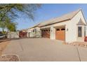 Two-car garage with wood-like doors and a long driveway at 2706 E Lovebird Ln, Gilbert, AZ 85297