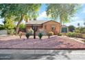 Attractive brick home with desert landscaping, trees and a detached garage at 311 W Georgia Ave, Phoenix, AZ 85013