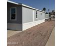 Rear view of gray manufactured home and gravel yard at 320 E Mckellips Rd # 50, Mesa, AZ 85201