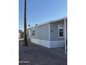 Side view of gray manufactured home with desert landscaping at 320 E Mckellips Rd # 50, Mesa, AZ 85201