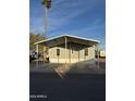 Gray manufactured home with carport and desert landscaping at 320 E Mckellips Rd # 50, Mesa, AZ 85201