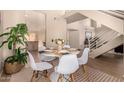 Well-lit dining area with a round table, seating for six, and view of the staircase at 3801 E Kent Dr, Phoenix, AZ 85044