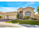 Tan two-story home with a tile roof, landscaping, and a two-car garage at 7439 E Beryl Ave, Scottsdale, AZ 85258