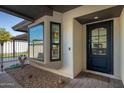 Front entry with modern black door and sidelights, and a small cactus garden at 7605 E Via De Lindo --, Scottsdale, AZ 85258