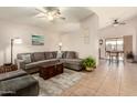 Cozy living room with tile floors, ceiling fan, and gray sectional sofa at 8553 N 112Th Ave, Peoria, AZ 85345