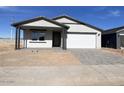 New construction home with gray siding, white garage door, and a paved driveway at 9534 W Luxton Ln, Tolleson, AZ 85353