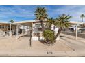 Tan mobile home with carport, palm trees, and paved driveway at 11411 N 91 Ave # 56, Peoria, AZ 85345