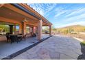 Covered patio with stone flooring, seating area, and mountain views at 13050 W Pinnacle Vista Dr, Peoria, AZ 85383