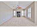 Spacious living room with a fireplace, TV, ceiling fan, and plantation shutters on multiple windows at 14250 W Wigwam Blvd # 2822, Litchfield Park, AZ 85340