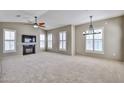 Bright, open living room featuring a fireplace, ceiling fan, and many shuttered windows at 14250 W Wigwam Blvd # 2822, Litchfield Park, AZ 85340