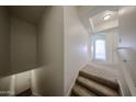 Carpeted stairs lead to a bright hallway, showcasing neutral tones and modern design at 14250 W Wigwam Blvd # 2822, Litchfield Park, AZ 85340