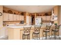Spacious kitchen with light wood cabinets and a breakfast bar at 16019 W Kino Dr, Surprise, AZ 85374