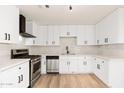 Updated kitchen featuring new stainless steel appliances, white cabinets, updated lighting and hardwood floors at 2227 W Paradise Dr, Phoenix, AZ 85029