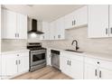 Beautiful kitchen featuring new stainless steel appliances, white cabinets, updated lighting and hardwood floors at 2227 W Paradise Dr, Phoenix, AZ 85029