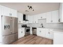 Modern kitchen with stainless steel appliances, white cabinets, new countertops, and wood-look flooring at 2227 W Paradise Dr, Phoenix, AZ 85029