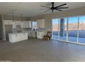 Modern kitchen with white cabinets, island, and sliding door access to patio at 28304 N 220Th Ave, Wittmann, AZ 85361