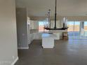 Open concept kitchen with island, white cabinets, and tile flooring at 28304 N 220Th Ave, Wittmann, AZ 85361