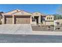 Inviting home featuring a 3-car garage, desert landscaping, and classic Southwestern architecture at 30696 N 130Th Ln, Peoria, AZ 85383