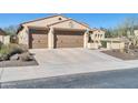 Inviting home featuring a 3-car garage, desert landscaping, and classic Southwestern architecture at 30696 N 130Th Ln, Peoria, AZ 85383