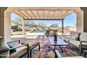Inviting covered patio overlooking a pool with comfortable seating and a stylish outdoor rug at 30696 N 130Th Ln, Peoria, AZ 85383