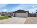 Single story home with brick accents, a spacious driveway, and a well-manicured lawn at 7331 W Aster Dr, Peoria, AZ 85381