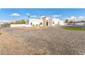 Wide exterior view highlighting the house's modern design, extensive paved driveway, and manicured landscaping at 7860 E Davenport Dr, Scottsdale, AZ 85260