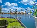 Picturesque waterfront homes with lush greenery, palm trees, and boats on a serene lake under a beautiful sunny sky at 10120 E Topaz Dr, Scottsdale, AZ 85258