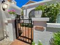 This home's entryway features an elegant wrought iron gate and manicured landscaping at 10120 E Topaz Dr, Scottsdale, AZ 85258