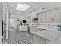 Bright, modern kitchen with white cabinets, stainless appliances, and a patterned black and white tile floor at 10120 E Topaz Dr, Scottsdale, AZ 85258
