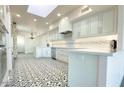 Modern kitchen with white cabinets, quartz countertops, and patterned tile floors at 10120 E Topaz Dr, Scottsdale, AZ 85258