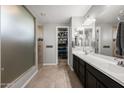 Bathroom with double vanity, large mirrors, walk-in closet, and a glass-enclosed shower at 10129 E Ampere Ave, Mesa, AZ 85212