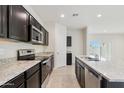 Modern kitchen with dark cabinets, granite counters, and stainless steel appliances at 1144 Se Mullberry St, Florence, AZ 85132