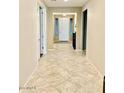 Bright hallway featuring neutral walls and tile flooring leading to the front door at 15704 W Taylor St, Goodyear, AZ 85338