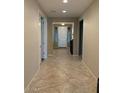 Long hallway with tile flooring connecting the home's living spaces and bedrooms at 15704 W Taylor St, Goodyear, AZ 85338