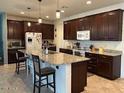 Bright eat-in kitchen boasts dark wood cabinetry, stainless steel appliances, and granite countertops at 15704 W Taylor St, Goodyear, AZ 85338