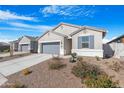 Single-story home boasts a gray stucco exterior, desert landscaping, gray garage door, and inviting curb appeal at 2530 W Sable Ave, Apache Junction, AZ 85120