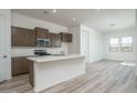 Modern kitchen with island, stainless steel appliances, and wood cabinets at 2811 N 212Th Dr, Buckeye, AZ 85396