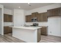 Modern kitchen with island, stainless steel appliances, and wood cabinets at 2811 N 212Th Dr, Buckeye, AZ 85396