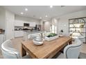 Kitchen island with granite countertop and wooden dining table at 36060 W San Ildefanso Ave, Maricopa, AZ 85138