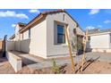 Charming single-story home with a small tree, stucco siding, and a well-maintained brick driveway at 4388 N 203Rd Dr, Buckeye, AZ 85396