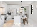 Modern white kitchen with stainless steel appliances and large island at 4388 N 203Rd Dr, Buckeye, AZ 85396