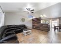 Spacious living room featuring tile flooring, ceiling fan, and a stylish wood plank accent wall at 480 E Bart Dr, Chandler, AZ 85225