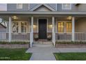 Charming front porch with brick accents, black door, and stylish lighting at 5344 E Catalina Ave, Mesa, AZ 85206